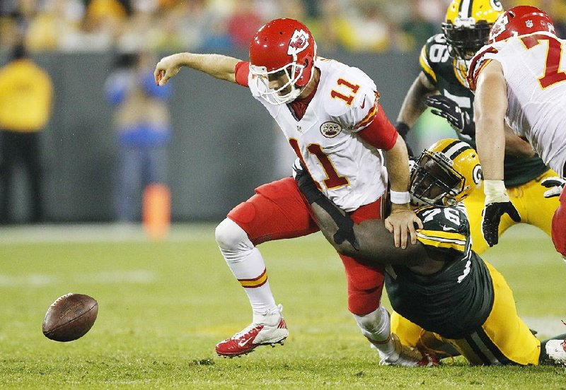 Kansas City Chiefs quarterback Alex Smith, being dragged down by Mike Daniels of the Green Bay Packers, threw an interception and was sacked five times during the Chiefs’ 38-28 loss Monday night. 