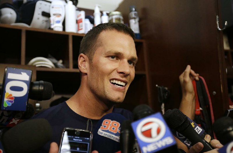 New England Patriots quarterback Tom Brady speaks with members of the media in the locker room before an NFL football practice, Wednesday, Sept. 16, 2015, at Gillette Stadium, in Foxborough, Mass. 