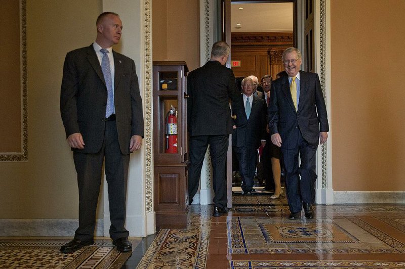 Senate Majority Leader Mitch McConnell (right) leaves a Republican caucus meeting Tuesday at the Capitol. McConnell said talks on a long-term budget deal should start “very soon.” 