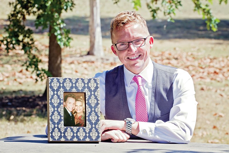 Carl Carter Jr. is shown with a picture of him and his mother, slain real estate agent Beverly Carter.