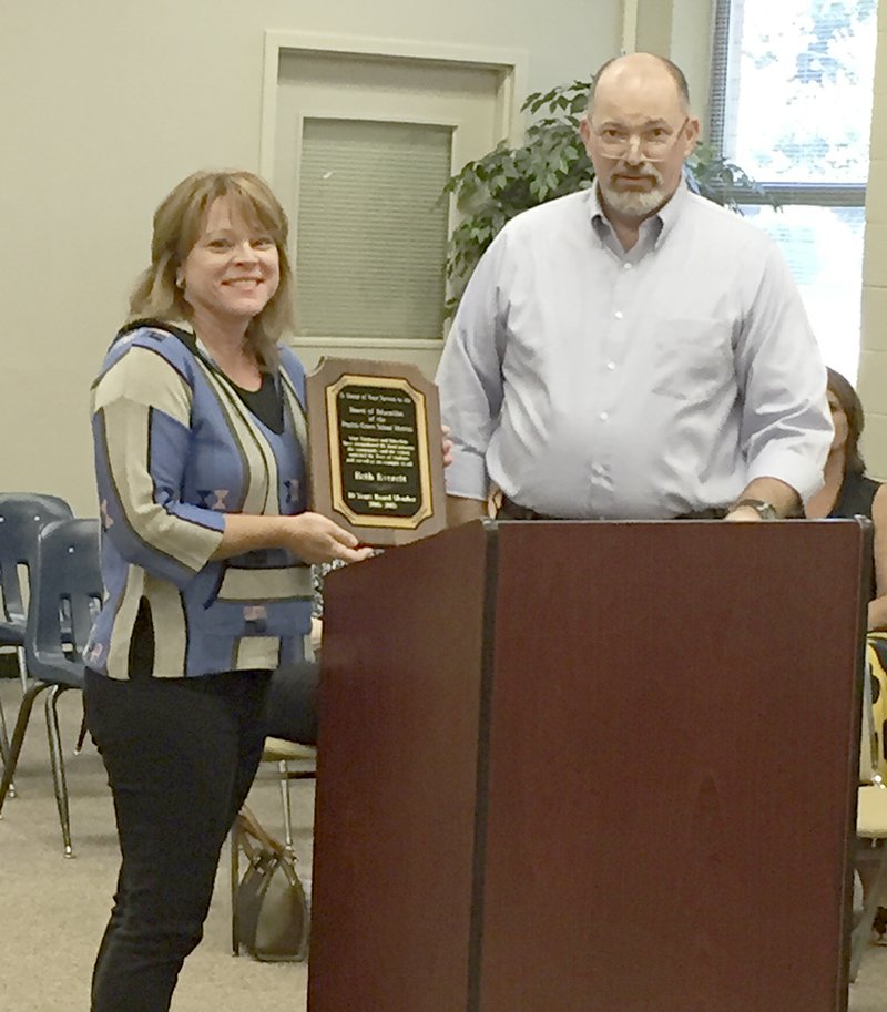 COURTESY PHOTO Allen Williams, superintendent of Prairie Grove School District, presents a plaque to outgoing board member Beth Everett in appreciation for her service to the district. Everett served on Prairie Grove School Board for 10 years and her last meeting was Sept. 21. She did not seek re-election to another term.
