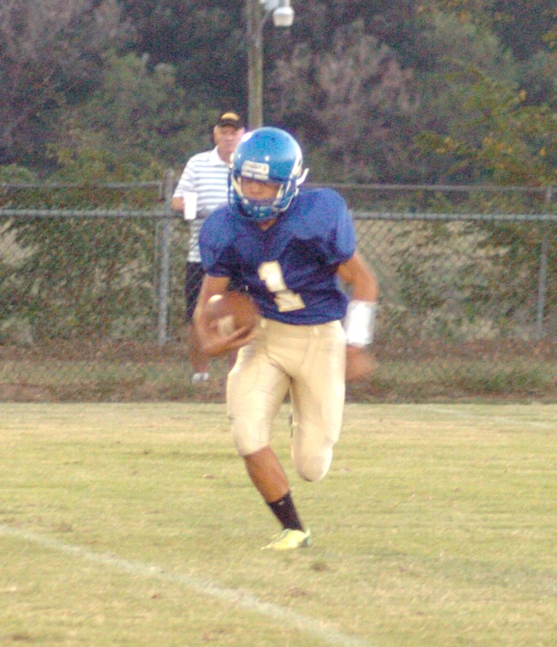 Photo by Mike Eckels Leng Lee (Decatur #1), on a quarterback keeper, finds an opening in the defensive line during the Decatur-Hackett football game at Bulldog Stadium in Decatur on Sept. 25. The Bulldogs lost to the Hornets, 49 to 6.