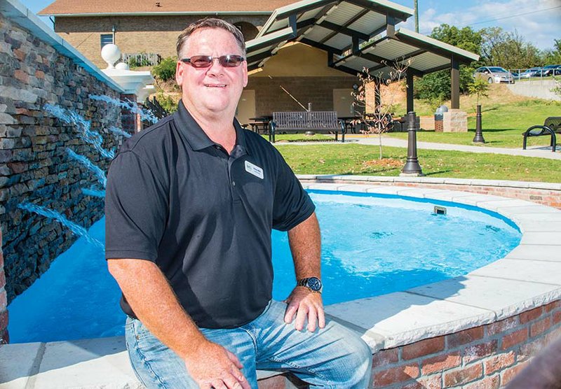 Stacey Mills, director of Heber Springs Parks and Recreation, sits by the fountain in Eagle Bank Park at Main and Second streets in downtown Heber Springs. Mills said the park, dedicated last month, is a “great asset” for the city. He also said another parks employee will need to be hired to maintain the park.