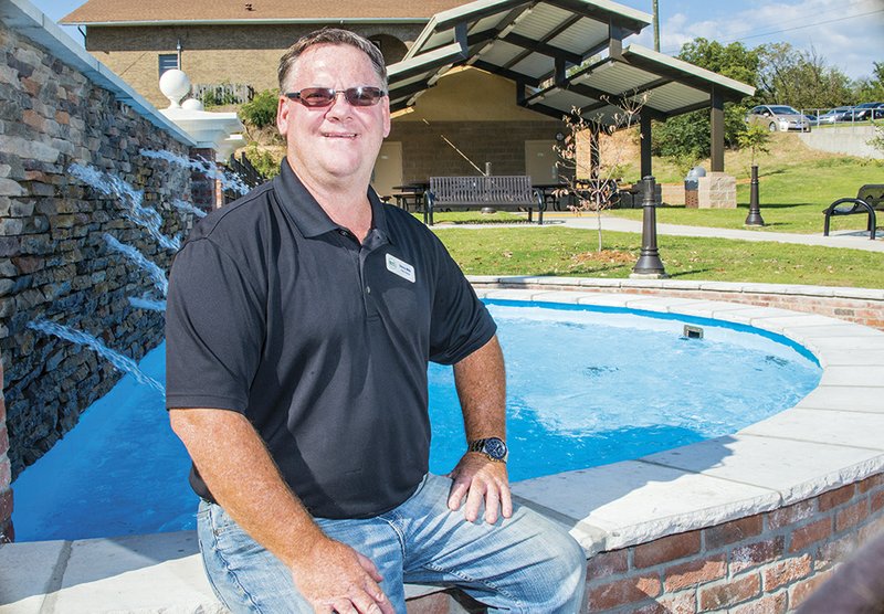 Stacey Mills, director of Heber Springs Parks and Recreation, sits by a fountain at Eagle Bank Park on Main Street. The park was built on a shale pit on property that Eagle Bank & Trust donated to the city. The land is at the intersection of Main and Second streets, which boasts the highest traffic count of any intersection in Cleburne County, said Jeff Lynch, president of Eagle Bank & Trust.