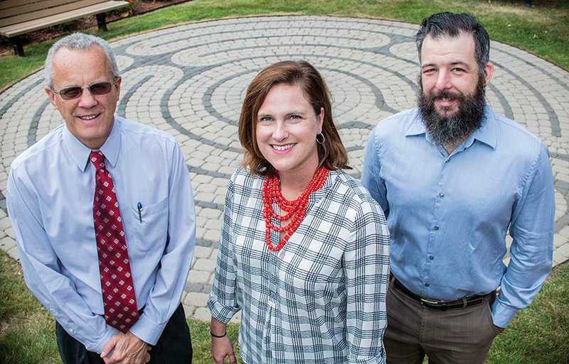 Paul Mehl, from left, Amy Baldwin and Brian James stand in front of the labyrinth at the University of Central Arkansas in Conway. The inaugural UCA Day of Mindfulness is scheduled for 9 a.m. to 4 p.m. today, and walking the labyrinth is one of the activities. Mehl, associate dean of the College of Liberal Arts, had the idea for the labyrinth, which was built in 2013 south of State Hall. Baldwin is director of University College and leads her students through relaxation techniques, and James, an instructor of English, oversees the labyrinth as resident master of the EDGE Residential College.