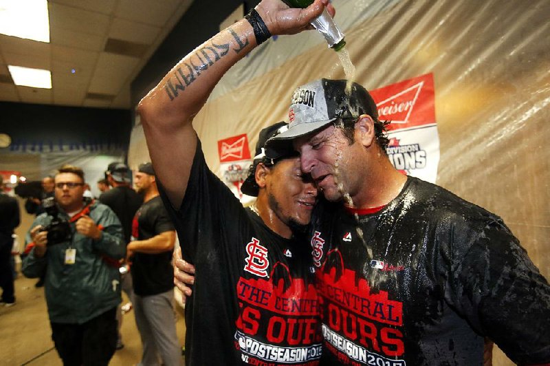 St. Louis Manager Mike Matheny (right) and pitcher Carlos Martinez celebrate after the Cardinals’ 11-1 victory over Pittsburgh in the second game of a doubleheader Wednesday in Pittsburgh. The victory clinched the National League Central for the Cardinals, their third consecutive title.
