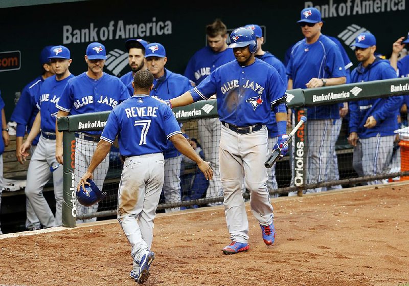 Toronto’s Ben Revere (7) is congratulated by teammate Edwin Encarnacion after scoring in the fifth inning of the Blue Jays’ 15-2 victory over the Baltimore Orioles in the first game of a doubleheader Wednesday in Baltimore.