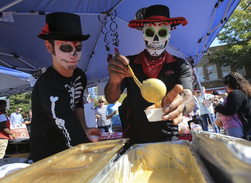 David Young (left) and Antonio Nelson dish up cheese dip for On The Border's Liquid Gold team at the 2014 World Cheese Dip Championship in Little Rock. This year's event is set for Saturday, Oct. 31, 2015.


