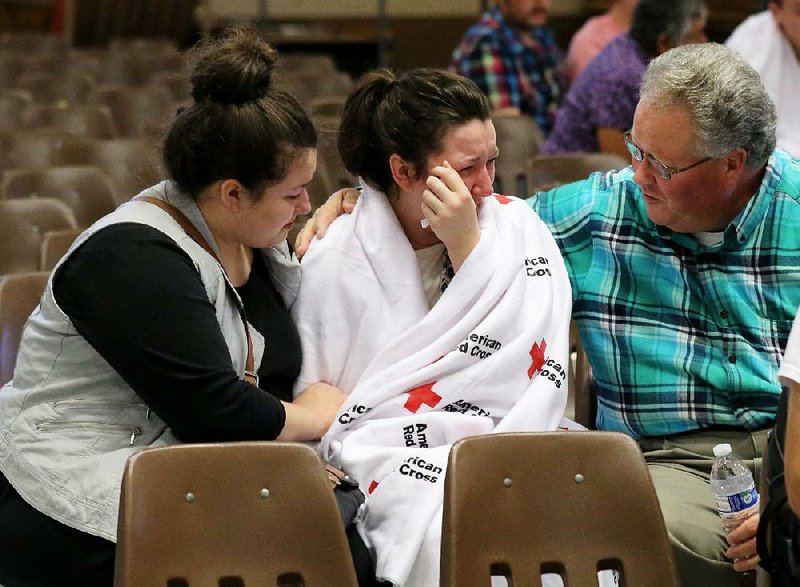 Hannah Miles (center) is comforted by her sister Hailey and her father, Gary, after a shooting Thursday at Umpqua Community College in Roseburg, Ore. 