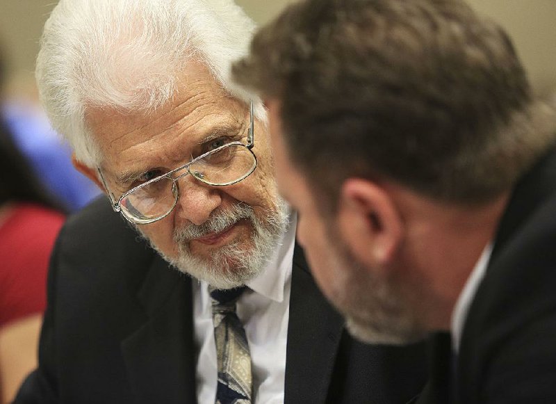 Hal Stanley (left), who battled the Department of Human Services after it took custody of his seven children, talks with his attorney, Joseph Churchwell, on Thursday before testifying before the legislative Joint Performance Review Committee in Little Rock. Lawmakers asked questions about the state agency’s actions.