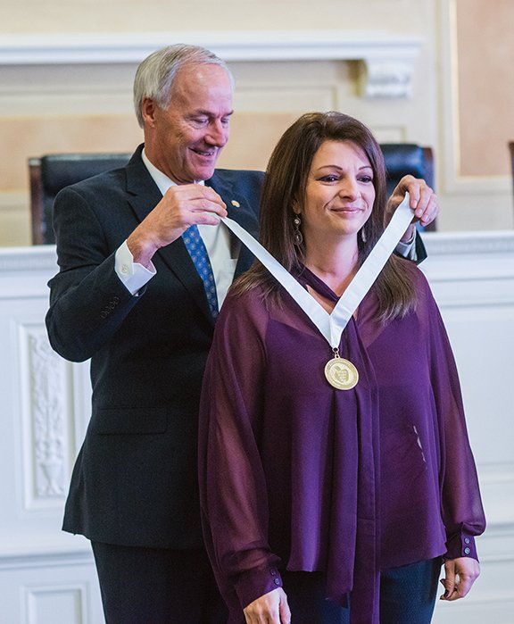 Stephanie Goodman of Hot Springs is one of four finalists for the 2016 Arkansas Teacher of the Year award. Shown here, Gov. Asa Hutchinson presents Goodman with a medallion during the 2016 Arkansas Teacher of the Year Recognition Event held Sept. 17 at the state Capitol in Little Rock. Goodman teaches sixth-grade math at Hot Springs Intermediate School.