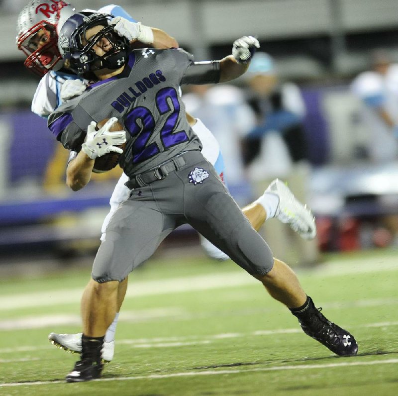 Luke Rapert of Fayetteville is tackled by his face mask by Max Moore of Fort Smith Southside during Friday’s game at Harmon Stadium in Fayetteville. Visit nwadg.com/photos to see more photographs from the game.