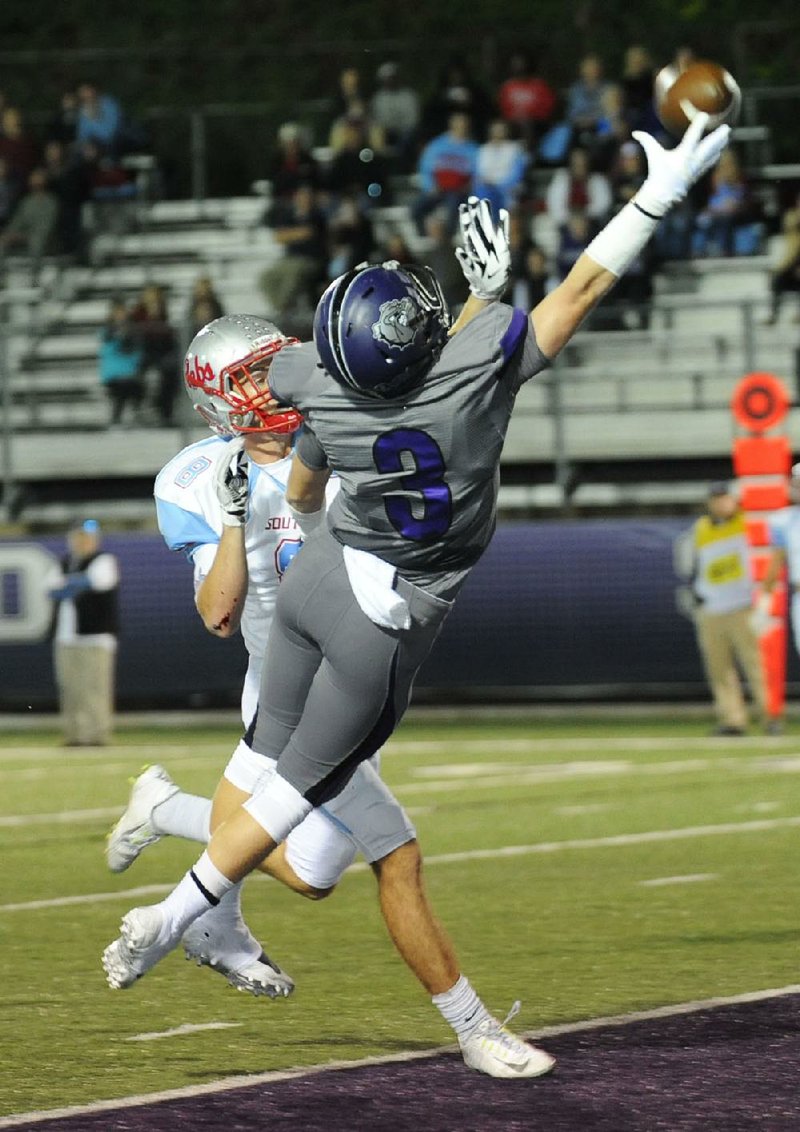 Barrett Banister (3) of Fayetteville reaches to catch a high throw over Jace McCrea of Fort Smith Southside on Oct. 2, 2015, at Harmon Stadium in Fayetteville.