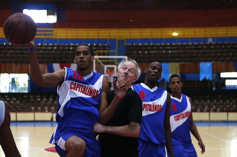 Gov. Asa Hutchinson plays basketball against a Cuban team Tuesday in Havana. Hutchinson and a delegation from Arkansas met with Cuban officials this week to explore trade opportunities.