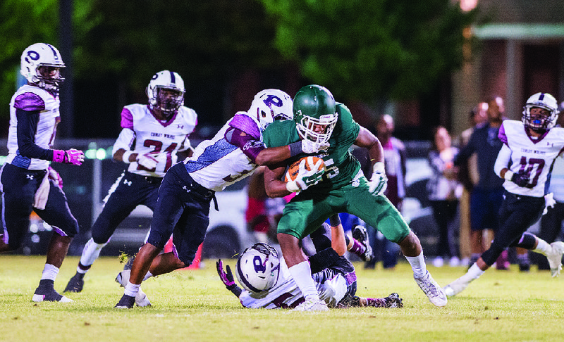 Episcopal Collegiate running back RJ Rice (right) gets pulled down by Prescott defender Maleric Butler during Friday’s game at Wildcat Stadium in Little Rock. Prescott won 62-36. More photos from Friday’s games are available at arkansasonline.com/galleries.