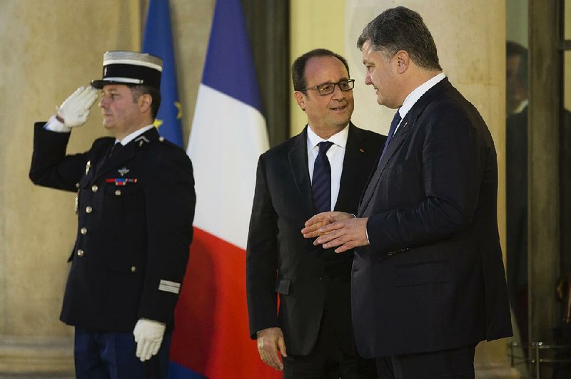 French President Francois Hollande (center) chats with Ukrainian President Petro Poroshenko after a meeting Friday in Paris on a peace plan for Ukraine.