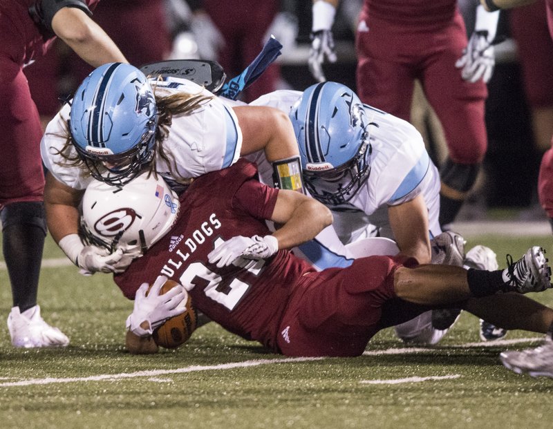 Jacob Robertson of Springdale Har-Ber tackles Springdale High’s Lucky Bannavong during Friday’s game at Jarrell Williams Bulldog Stadium in Springdale. Visit nwadg.com/photos to see more photographs from the game. 