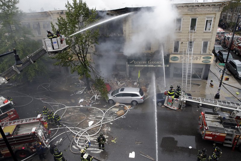 Firefighters work at the at the scene of an explosion at a three-story building in the Borough Park neighborhood in the Brooklyn borough of New York, Saturday, Oct. 3, 2015. Firefighters in New York say one person is dead and three more have been injured in an apparent explosion and fire. 