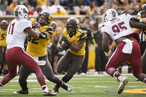 Missouri running back Ish Witter, center, runs between South Carolina's Dante Sawyer, right, and T.J. Holloman, left, behind the block of Clayton Echard during the first quarter of an NCAA college football game Saturday, Oct. 3, 2015, in Columbia, Mo. (AP Photo/L.G. Patterson)