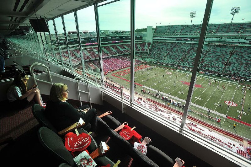 Hannah Story (left) and Cheryl Story of Fayetteville watch pre-game activities from the Arvest Bank suite in Donald W. Reynolds Razorback Stadium as the University of Arkansas prepares to play Texas Tech on Sept. 19. 