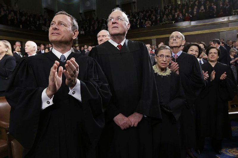 Chief Justice John Roberts (left) joins fellow Supreme Court members on the floor of the U.S. House for President Barack Obama’s 2013 State of the Union address. Months earlier, Roberts had found a narrow way to uphold Obama’s health care law, to the consternation of conservatives.