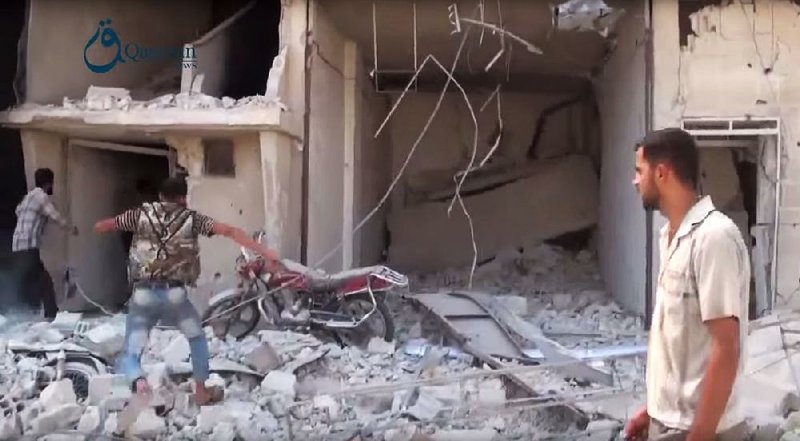 In this image from video provided by the Syrian activist group Qasioun News and verified by The Associated Press, Syrians look through the rubble of a building in Dair al-Asafeer outside Damascus after it was hit Thursday in a Russian airstrike. 
