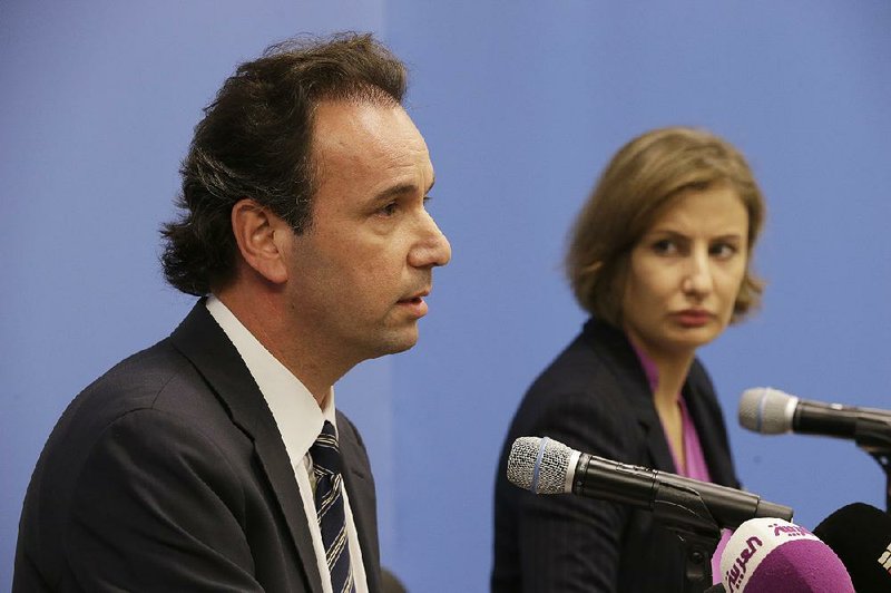 Syrian National Coalition President Khaled Khoja, left, is joined by Syrian National Coalition Special Representative to Lebanon Alia Monsour as he speaks to reporters during a news conference Wednesday, Sept. 30, 2015 at U.N. headquarters. 