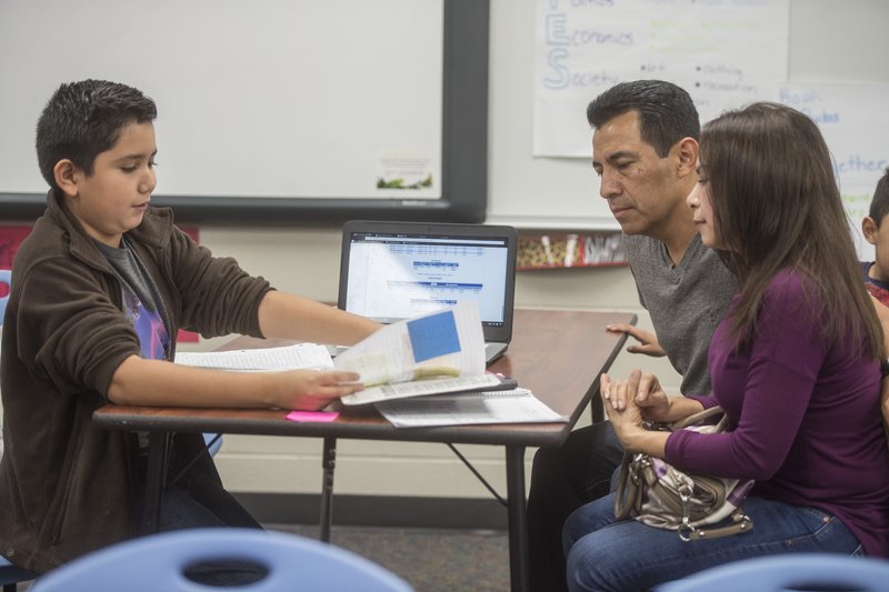 Matthew Clemente, 11, sixth-grader at Sonora Middle School, leads his parents, Herbert and Sonia Clemente, in a conference Thursday at the school in Springdale. The district is using more student led conferences than the traditional teacher led conferences. Matthew showed his parents his work and talked about the areas he excels in and where he may need a little more work. For more photos, go to www.nwadg.com/photos.