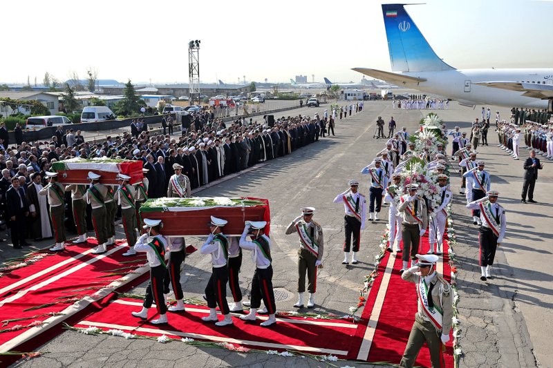 An Honor guard carries the coffins of Iranian hajj pilgrims who were killed in a deadly stampede in Mina near Mecca in Saudi Arabia on September 24, at Mehrabad airport in Tehran, Iran, Saturday, Oct. 3, 2015.