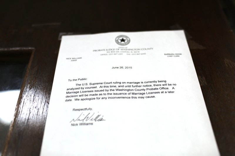 In this Wednesday, Sept. 23, 2015, photo, a notification posted on a door outside of the probate office states "there will be no marriage licenses by Washington County probate office issued by an Alabama probate judge, Nick Williams, a judge that is using a segregation-era law to avoid gay marriage in Chatom, Ala. 