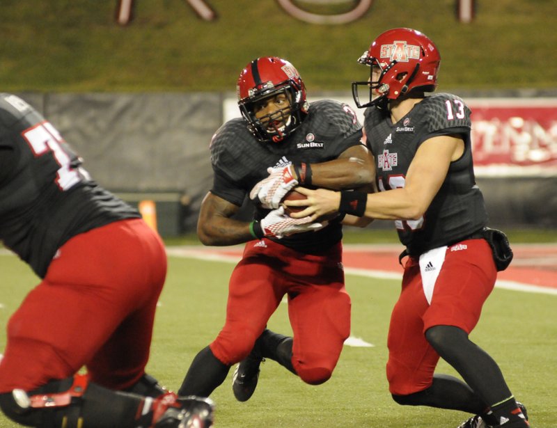 Arkansas State quarterback James Tabary (right) hands off to running back Michael Gordon during Saturday’s game at Centennial Bank Stadium in Jonesboro. Gordon rushed for 221 yards and 3 touchdowns on 26 carries in the Red Wolves’ 35-21 victory over Idaho.