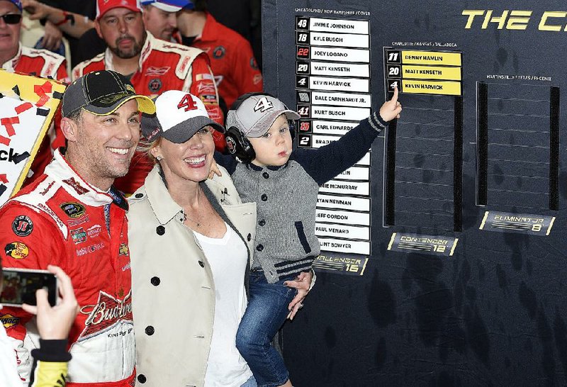 Kevin Harvick, left, his wife DeLana, center, and son Keelan, right, pose by the Chase Grid in Victory Lane after he won the NASCAR Sprint Cup series auto race, Sunday, Oct. 4, 2015, at Dover International Speedway in Dover, Del.