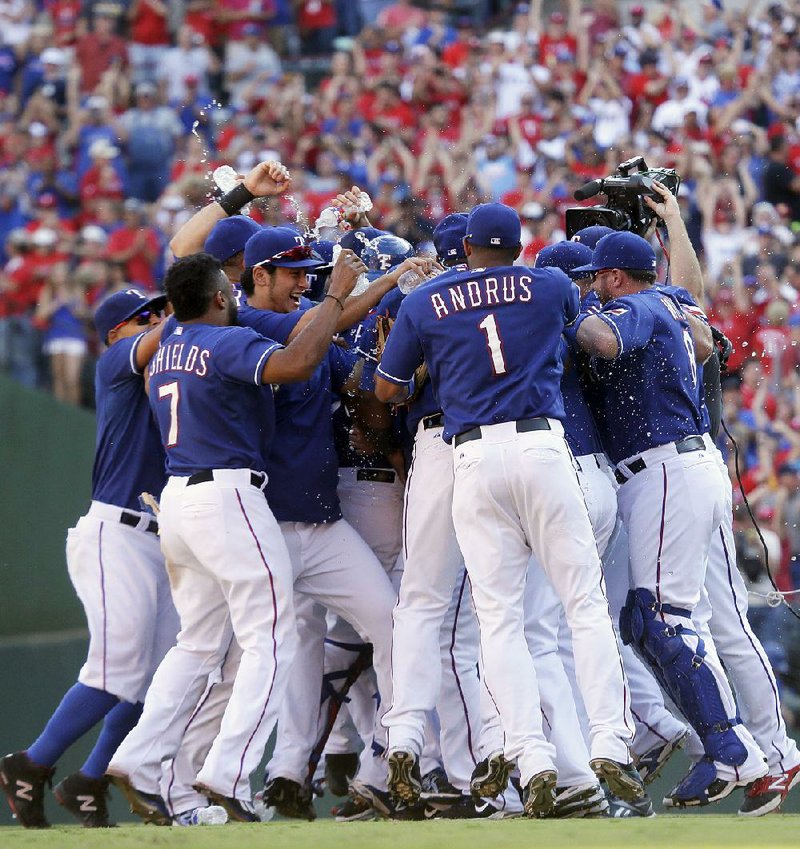 Texas players celebrate after the Rangers beat the Los Angeles Angels 9-2 on Sunday to win the American League West Division title for the first time since 2011. 
