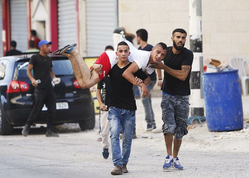 Palestinians carry an injured man during an Israeli military raid in the West Bank city of Jenin on Sunday. Israeli troops shot and wounded at least six Palestinians in violence during an arrest raid in the Jenin refugee camp, a Palestinian hospital director said.