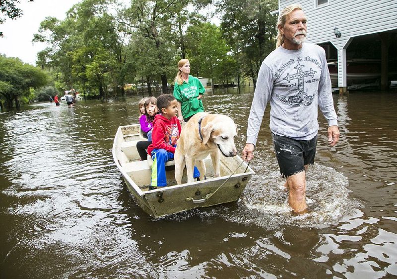 Jerry Hardy and his wife, Tracey, guide a boat through the flooded streets of Conway, S.C., after evacuating their home Monday.