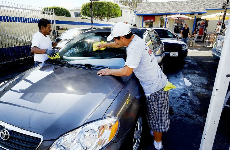 Carwash employees wipe down a vehicle in the Pacoimia section of Los Angeles in June. The Institute for Supply Management’s nonmanufacturing index, covering a number of industries that make up nearly 90 percent of the economy, fell in September to 56.9.
