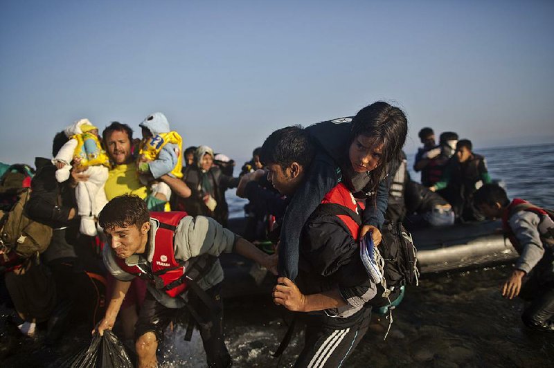 Migrants rush to the beach as they arrive on a dinghy from the Turkish coast to the northeastern Greek island of Lesbos on Monday.