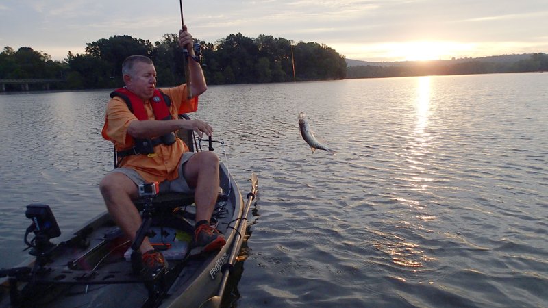 Mike McBride catches a crappie at sunrise Sept. 24 at Lake Sequoyah. He caught several using a jig under a bobber. Crappie fishing improves at the lake as the water cools, McBride said.