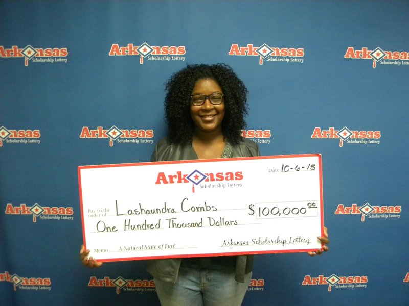 Pine Bluff resident Lashaundra Combs stands with her $100,000 check from the Arkansas Scholarship Lottery on Tuesday, Oct. 6, 2015.