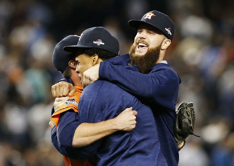 Dallas Keuchel (right) celebrates with teammates Luke Gregerson (left) and Carlos Gomez after the Houston Astros’ 3-0 victory over the New York Yankees on Tuesday night in the American League wild-card game at Yankee Stadium. Keuchel (Arkansas Razorbacks) allowed 3 singles and struck out 7 over 6 scoreless innings.