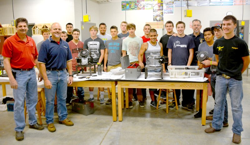 Janelle Jessen/Herald-Leader Mike Sellers, of Sellers Trading Post, and Honda donated 36 new four-cycle engines to the Siloam Springs High School for the small gasoline engine repair class. Sellers and agriculture teachers Rodney Ellis and Gene Collins are pictured with students from the repair class.