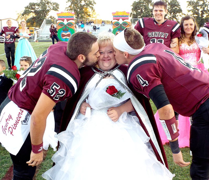 Photo by Randy Moll After being crowned homecoming queen at coronation ceremonies on Friday in Gentry, Mekalah Ramsey is kissed by homecoming kings Kaven Flesner and Jake Faulkenberry.