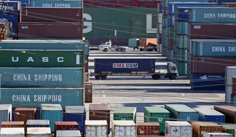 In this Feb. 12, 2015 file photo, trucks move containers at the Port of Los Angeles. The Commerce Department reports on the U.S. trade gap for August 2015 on Tuesday, Oct. 6, 2015.