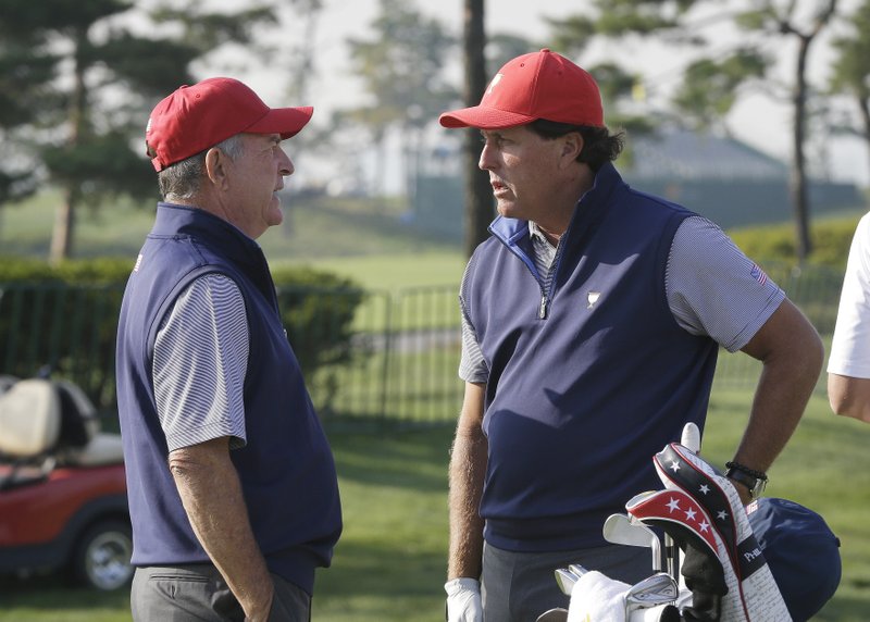 United States team captain Jay Haas, left, talks with his team player Phil Mickelson during a practice round ahead of the Presidents Cup golf tournament at Jack Nicklaus Golf Club Korea in Incheon, South Korea, Tuesday, Oct. 6, 2015. 