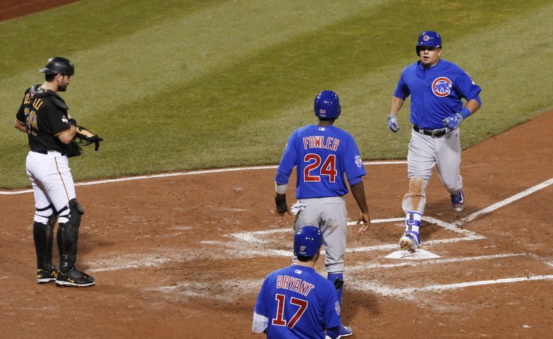Chicago Cubs' Kyle Schwarber, right, steps on home plate after he drove Dexter Fowler (24) in with a two-run home run in the third inning of the National League wild card baseball game against the Pittsburgh Pirates, Wednesday, Oct. 7, 2015, in Pittsburgh. Pittsburgh Pirates catcher Francisco Cervelli is at left. (AP Photo/Gene J. Puskar)
