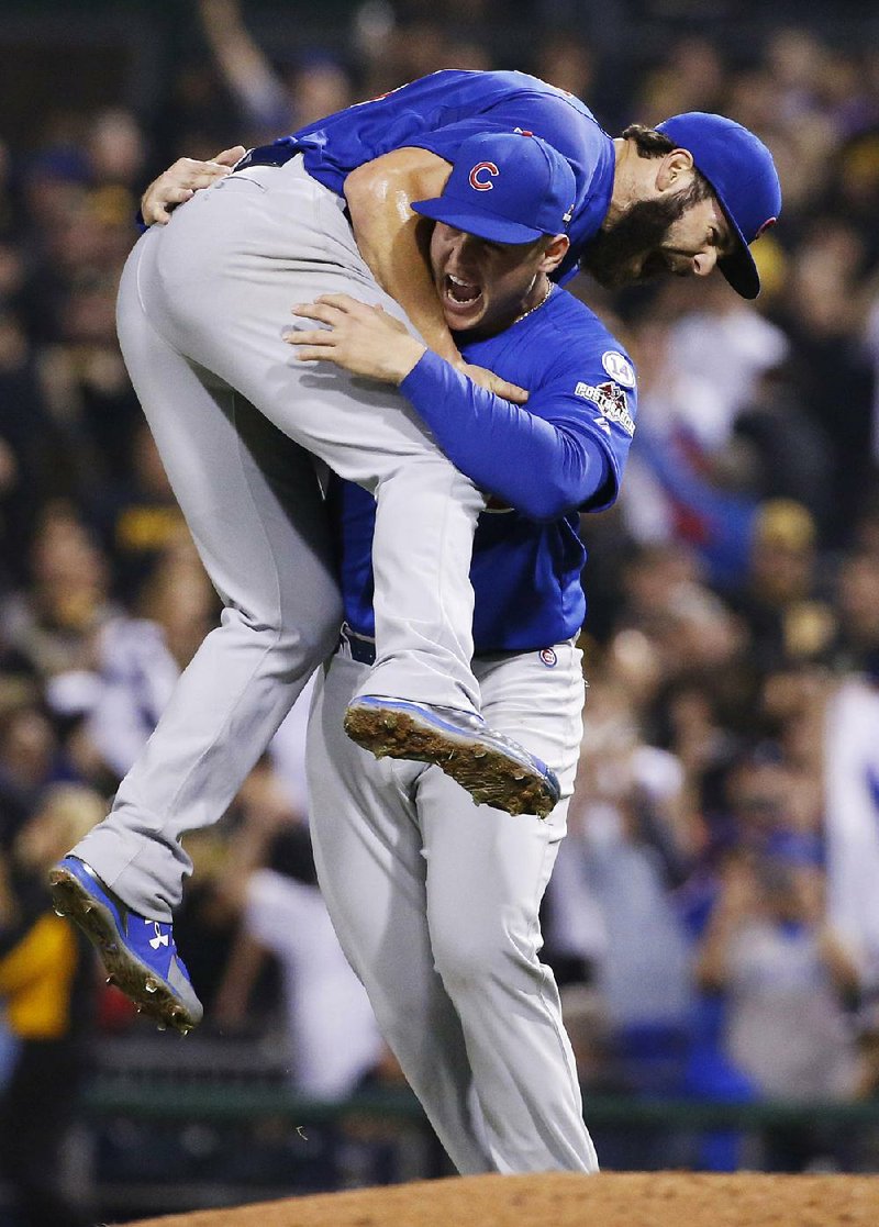 Chicago first baseman Anthony Rizzo picks up pitcher Jake Arrieta after the right-hander held Pittsburgh to four hits in the Cubs 4-0 victory, sending them to the NL division series against St. Louis.