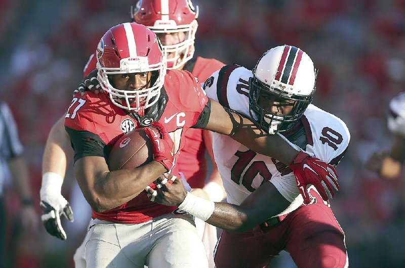 FILE - In this Sept. 19, 2015, file photo, Georgia running back Nick Chubb (27) tries to break free from South Carolina linebacker Skai Moore (10) during the first half of an NCAA college football game in Athens, Ga. No. 13 Alabama takes on No. 8 Georgia on Saturday in Tuscaloosa. (AP Photo/John Bazemore, File)