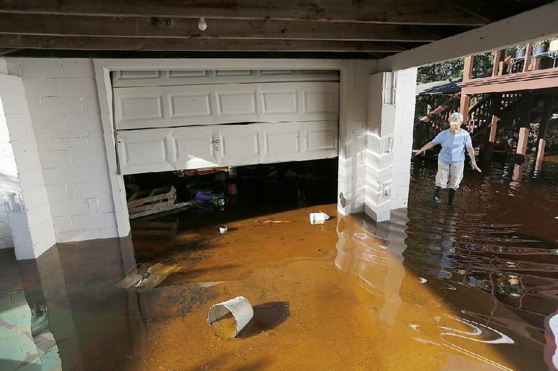 Roberta Albers checks on her home Wednesday after floodwaters started to recede at French Quarter Creek in Huger, S.C. 