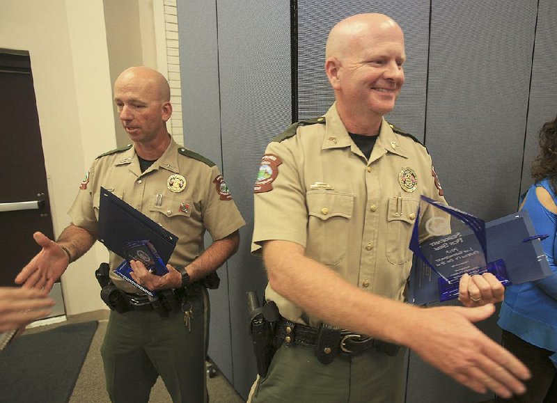 Arkansas Game and Fish officer Billy Williams (left) and Sgt. Ben Sisk are congratulated Wednesday afternoon after being named the Officers of the Year at the 13th annual Arkansas Law Enforcement Summit luncheon at Camp Robinson in North Little Rock. 