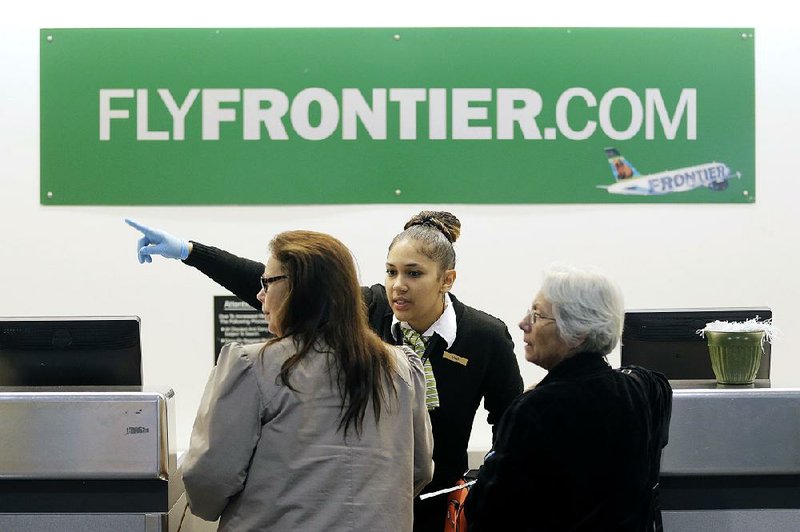 A Frontier Airlines employee directs passengers at Cleveland Hopkins International Airport in this file photo. Frontier is one of several airlines that are considered ultra-low-cost carriers.
